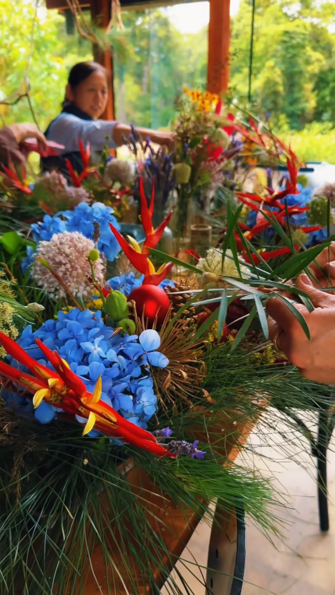 Arranjos florais sendo criados ao redor da mesa